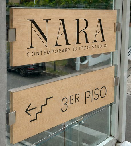 Letrero de madera de NARA Contemporary Tattoo Studio en el acceso al 3er Piso de Plaza Giardino.