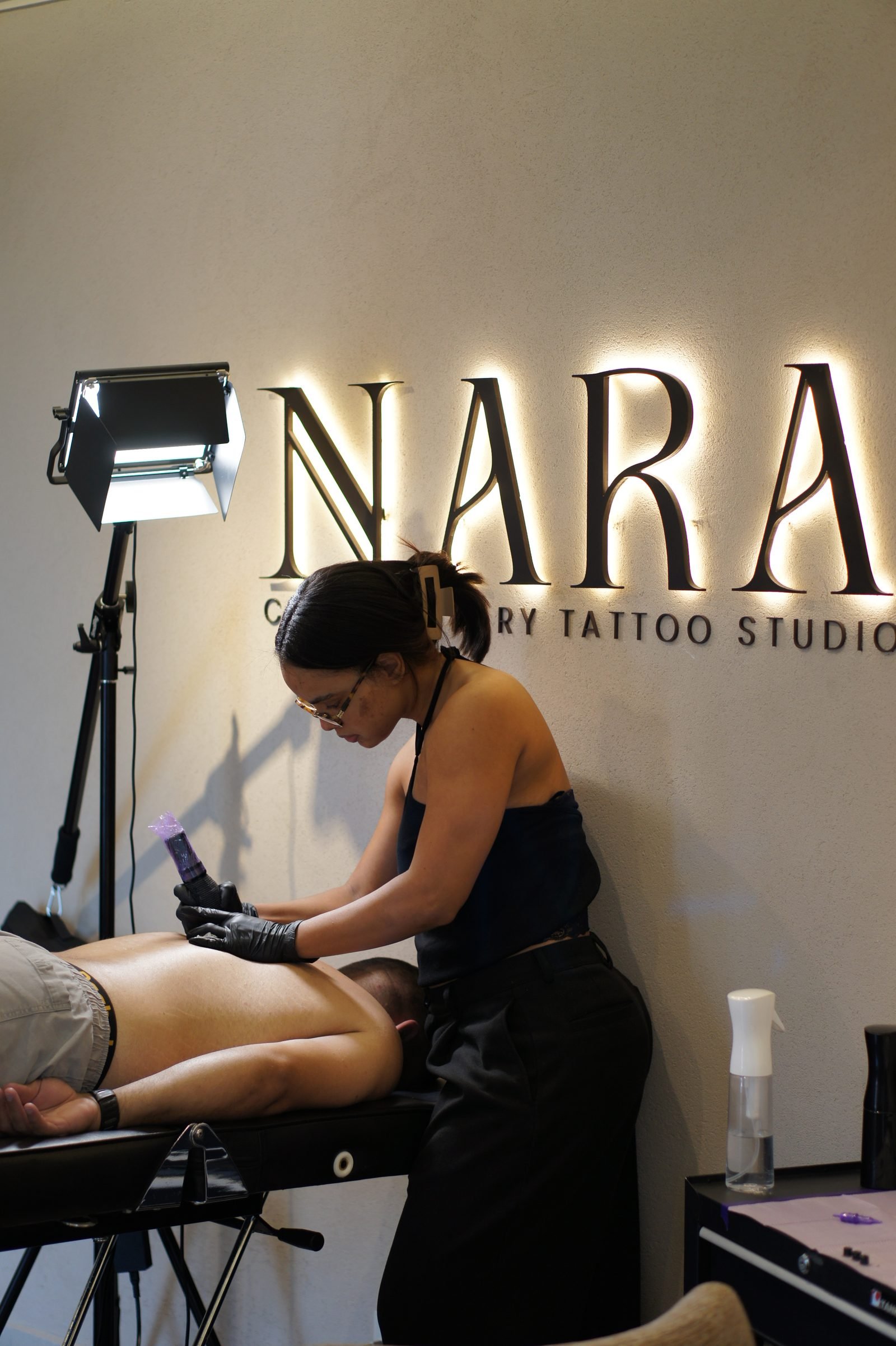 Melody Goris preparando el material de trabajo en el atelier NARA antes de una sesión de tatuaje.